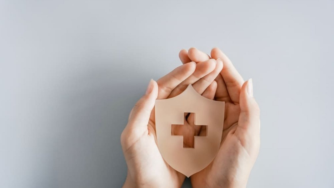 Mâini care țin un scut cu simbolul crucii, asigurare de sănătate, prim ajutor, asistență medicală și concept de bunăstare. Mâini care țin un scut cu simbolul crucii, asigurare de sănătate, prim ajutor, asistență medicală și concept de bunăstare.