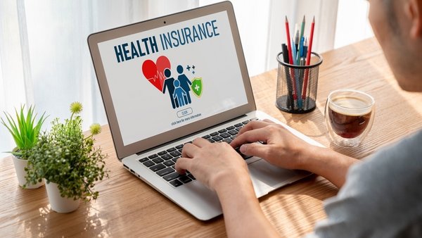 Imagine cu o persoana care compara doua optiuni de asigurare de sanatate Imagine cu o persoana care compara doua optiuni de asigurare de sanatate