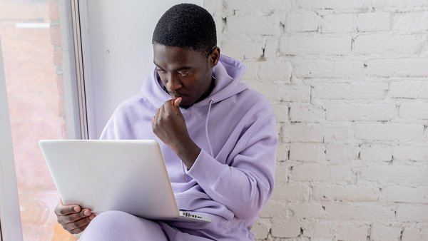 5 pași pentru planul tău de pensii Studentull stă cugetând în fața unui laptop
