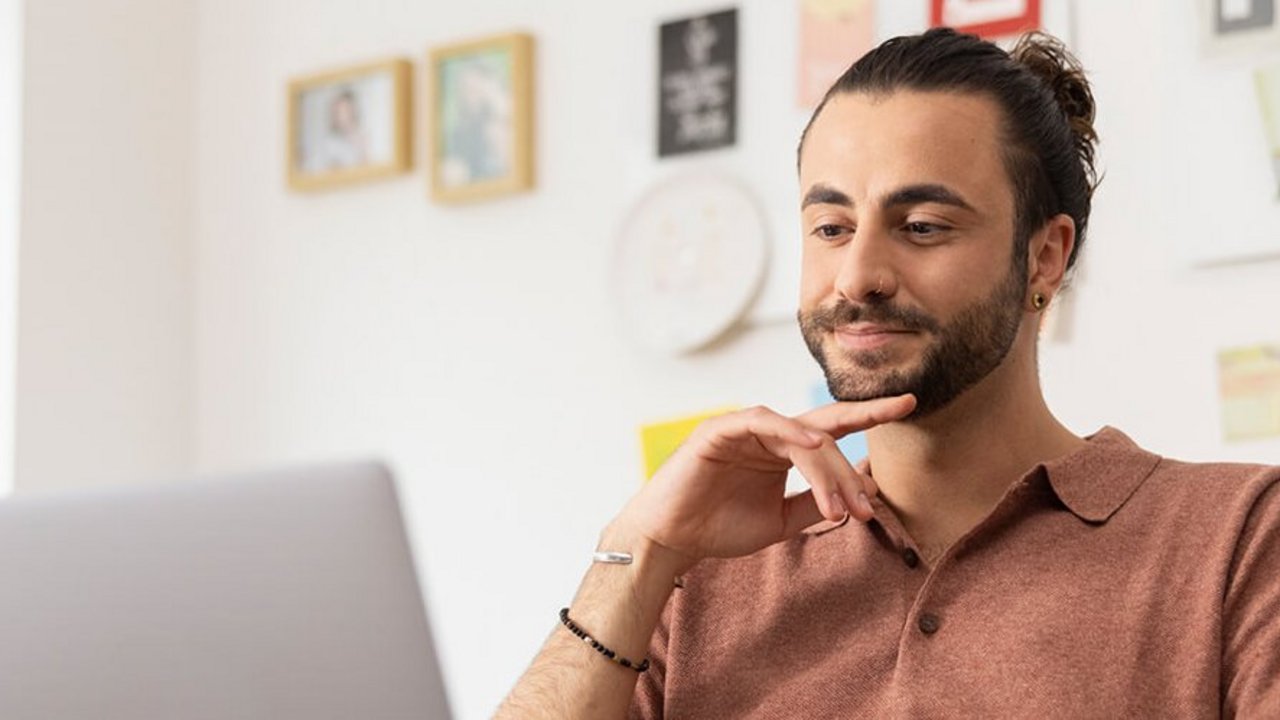 Barbat care se uita la laptop pentru a obtine informatii