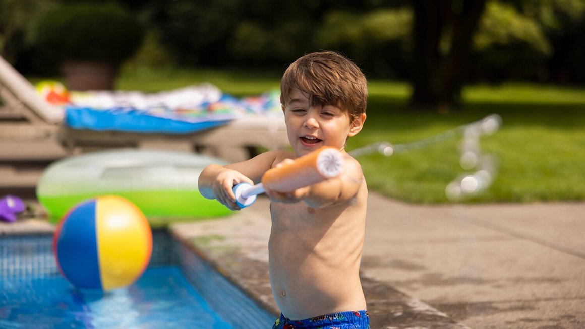 Copil la piscină cu pistol cu apă - Călătorește în siguranță  